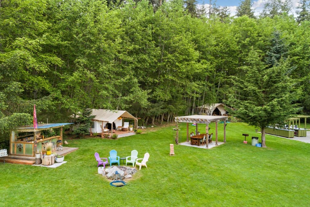 Grassy glamping site with tiki bar and outdoor kitchen