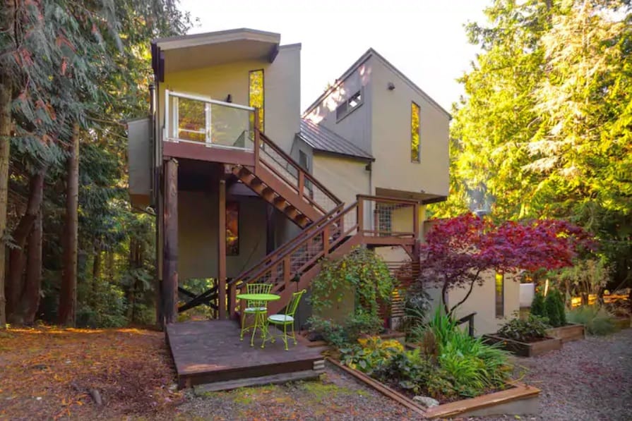 the nest treehouse Glamping in Washington State view from outside with stair and bushes