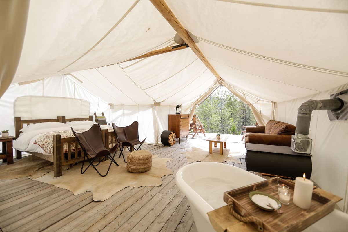 inside of tent at Under Canvas Glamping Glacier National Park with bed, bath and couch
