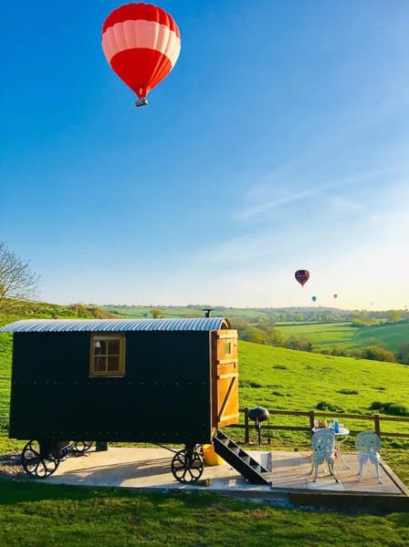 Shephards hut in the Cotswolds view with hot air balloons in the sky