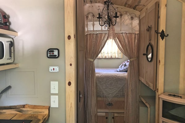 view down the hall with a bed in the back of a gypsy caravan