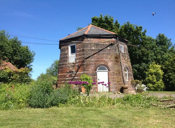 Ballingdon Mill Glamping Retreat  view of the windmill with garden around it