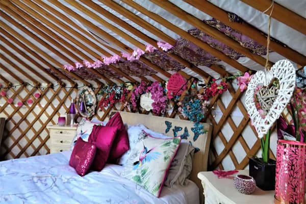 Lily Lake Essex Yurt with Hot Tub view of this Essex glamping yurt from the inside showing the bed and colorful heart decorations