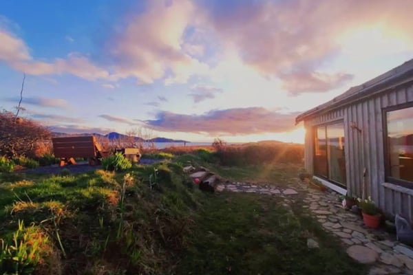 Cozy Coastal Eco-Cabin while Glamping Cork view of the cabin at sunset with a bench and firepit