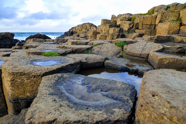 giants causeway location when glamping NI close up view of the pillars with a bit of rain fall and puddles