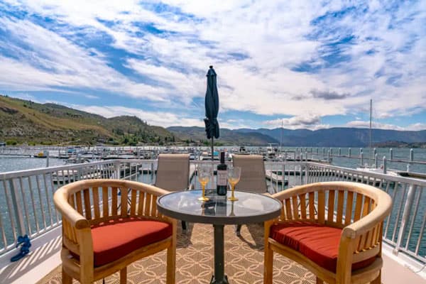 Luxury Houseboat glamping view of top deck of boat with chairs and wine