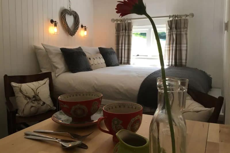 shepherds-hut inside view of bed and coffee cups
