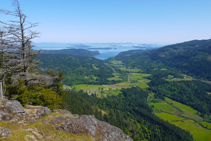 hiking on salt spring island view from a rock with the green valley and gulf islands in the background