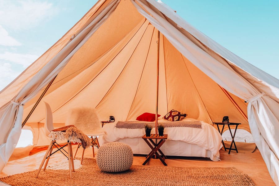 wander camp tent glamping moab view of inside tent with bed and chairs and pillows